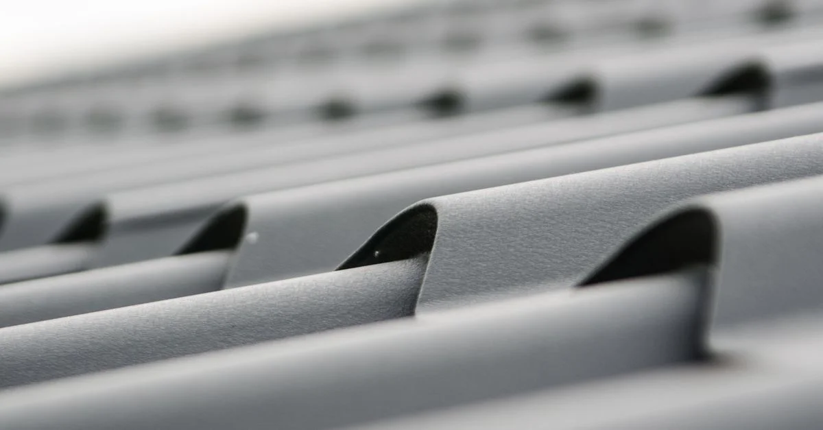 Gros plan détaillé de feuilles de toiture en métal gris montrant la texture et le design.