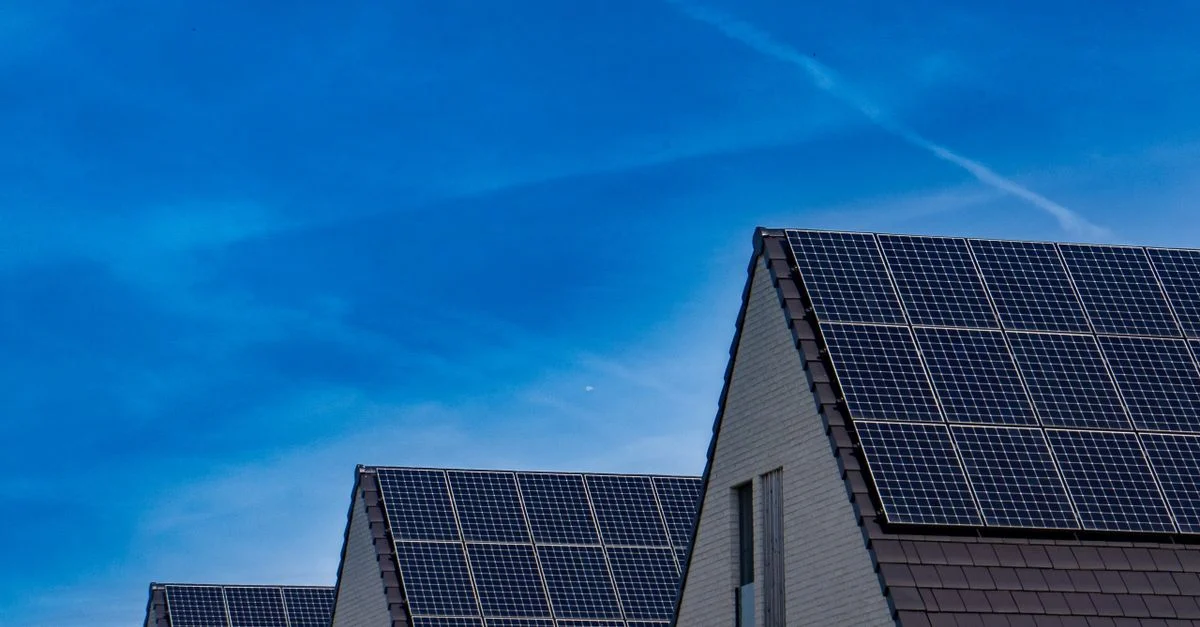 Maisons contemporaines avec des panneaux solaires sous un ciel bleu lumineux qui promeut l'énergie renouvelable.