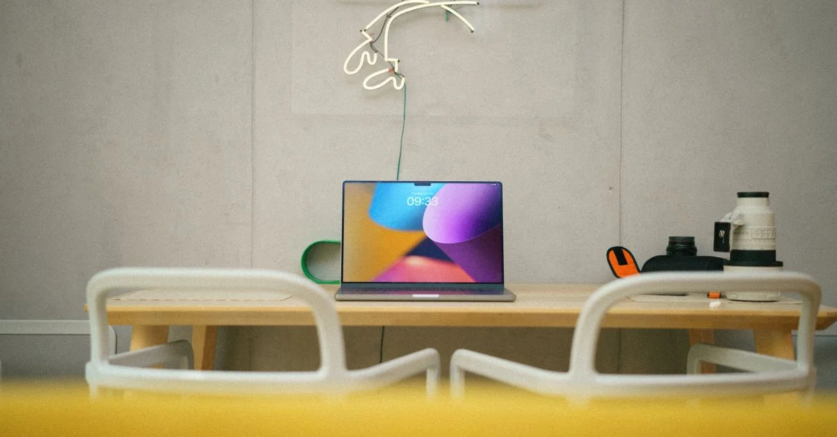 Bureau à domicile moderne avec ordinateur portable sur le bureau, art néon et design minimaliste.