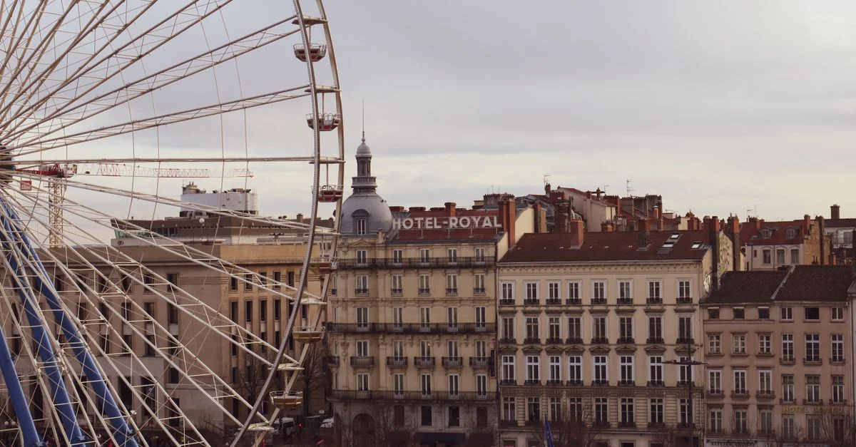 Une vue pittoresque d'une grande roue à côté de l'Hôtel Royal à Lyon, France, mettant en valeur une architecture classique.