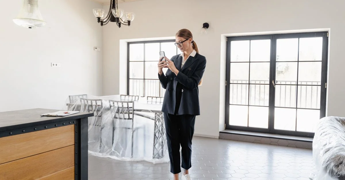 Agent immobilier prenant des photos à l'intérieur d'un appartement moderne et lumineux.
