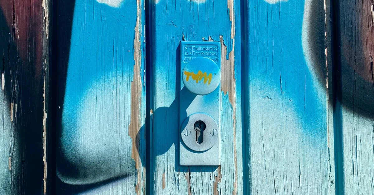 Gros plan sur une porte en bois vibrante entourée d'art graffiti autour d'un trou de serrure.