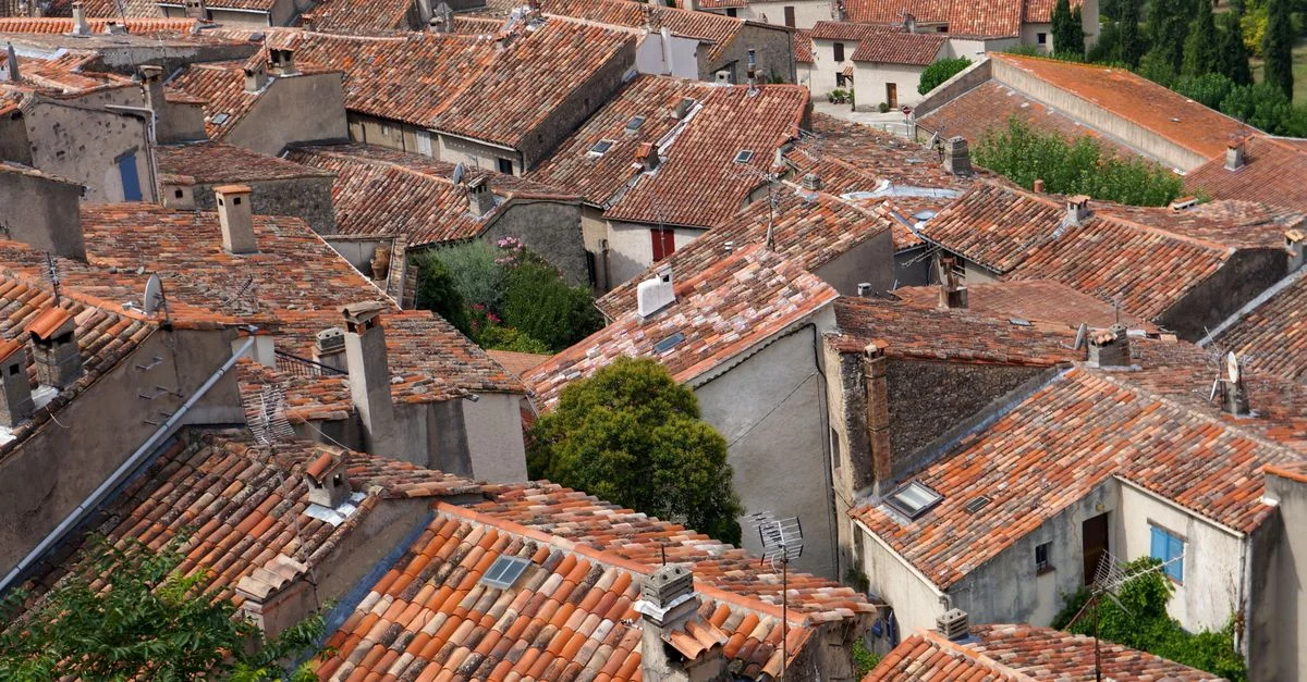Vue plongeante sur des toits en tuiles en terre cuite d'un charmant village italien, capturant l'essence de l'architecture rustique.